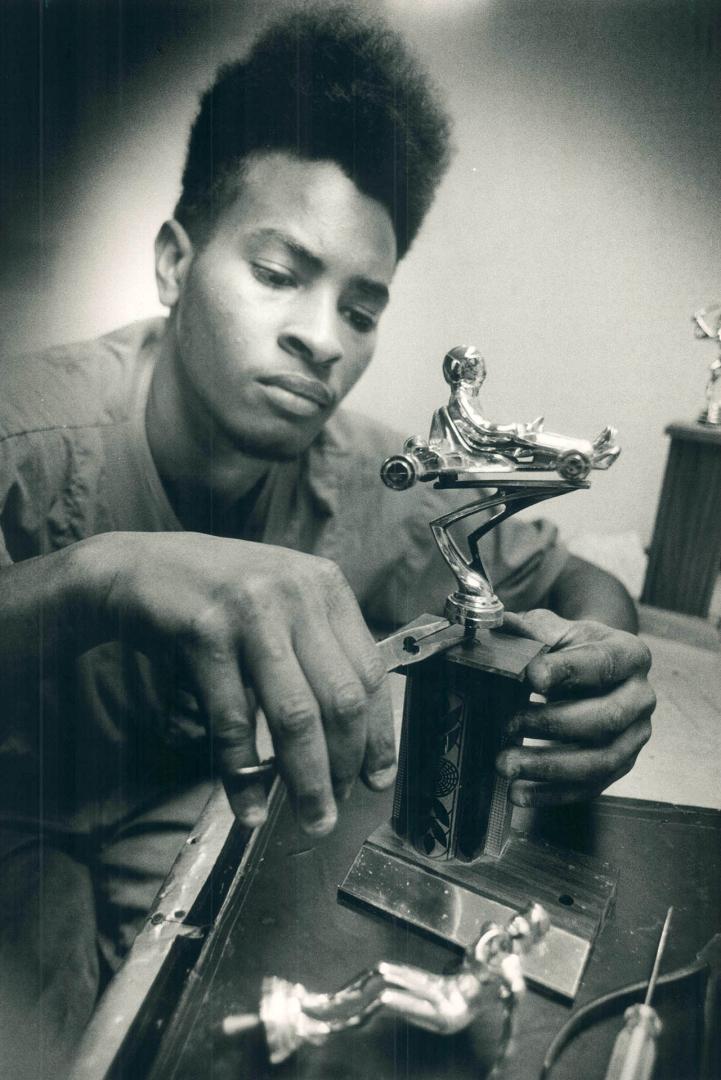 A sure winner, Barry Mitchell assembles a sports trophy for Rite Rubber Stamp of Toronto, which builds engraves signs and makes rubber stamps