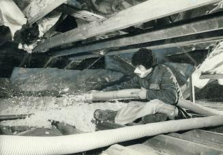 Wearing protective mask, Nick Muia of Dominion Insulation sprays rock wool insulation in the attic of a house on Saskatoon Dr., Etobicoke. Muia's olde(...)