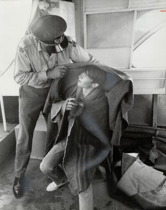 Rescued by Harbor Police, Bruce Ross, 16, is wrapped in blankets by patrol officer Alex Mitterhuben, one of the crewmen on Harbor Police patrol boat Nine