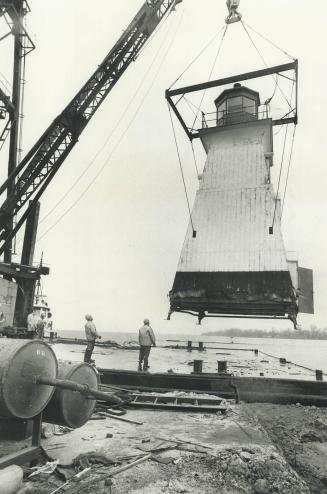 A Bit Of Lighthouse Keeping, A 32-foot-high lighthouse that has helped guide sailors through Toronto harbor's Eastern Gap since 1895 was hoisted away yesterday by a Harbor Commission derrick