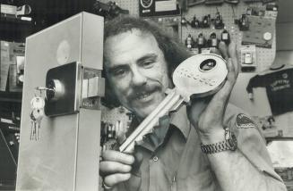 Make your home pick-proof: Locksmith Ron Reid and a large demonstration key for apartment-door cylinder lock