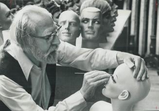 Artist Gully Jimpson paints on features and applies eyelashes to the heads before the manikins are assembled