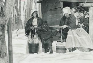 Spring and the sap is running, Trying the pioneer style of collecting sap for ample syrup, Eugene Draper, 6, of Scarborough, shoulders a yoke with two(...)