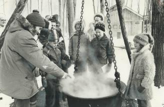 The old-fashioned way of boiling maple syrup is explained to visitors by biologist Gary Hutton of the Halton region Conservation Authority yesterday, (...)
