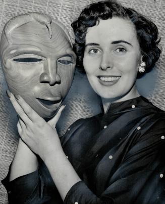 Mavis harmer's pretty smile contrasts with the scowl on the authentic African death mask which she holds