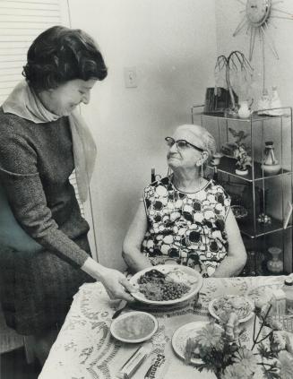 Hot dinner is delivered by Mrs. Ruth Crozier, left, to Mrs. F. H. Orr, who is 80, at her apartment in Clarkson. This is one of the good works performe(...)