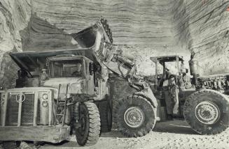 Dump Trucks loading rocksalt in the Sifto Salt mine at Goderich, Ontario, had to be taken apart to be lowered into the mine, then re-assembled. Each n(...)