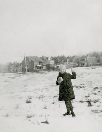 Image shows a girl standing on the Wychwood library lawn in winter.
