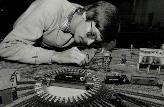 On The Right Track, Walter Reid adjusts track yesterday as he helps the Toronto N Gauge Model Railroad Club set up a display at the 1990 Hobby Show, a(...)