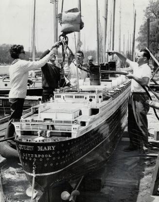 At left RCYC member Ken Greig in SCUBA gear goes beneath water to attach cables around sunken ship