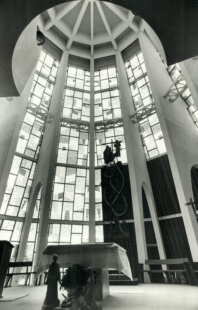 The circular sanctuary is enclosed by multicolored glass, which creates a kaleidoscope of color