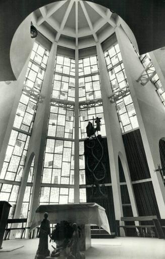 The circular sanctuary is enclosed by multicolored glass, which creates a kaleidoscope of color