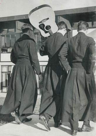 A guitar swings on the back of one of these black-cassocked teenagers strolling through grounds of Christian Brothers monastery. Peter Andrews, 18, St(...)