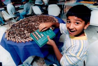Money flows from fountain, Lloyd Cowan, 10, of Mississauga tallies up some of the thousands of coins tossed in the Square One Fou the last six months,(...)