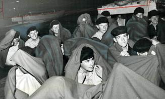 Sea cadets less seriously ill sit huddled under blankets last night near the Haida at Ontario Place awaiting treatment from the special ambulance bus (...)