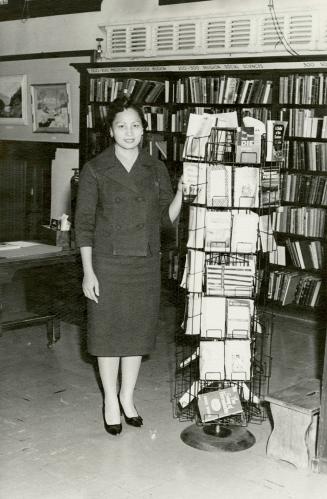 Mrs Leticia Maloles, Colombo Plan trainee from the Philippines, at paperback rack Beaches Library