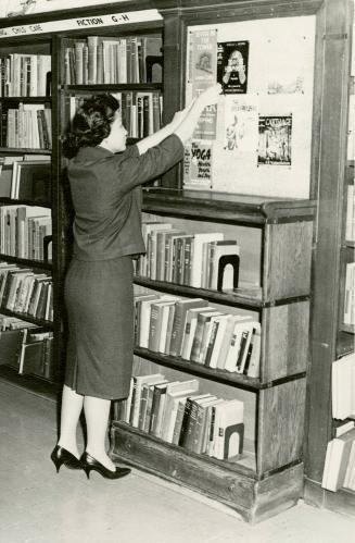 Mrs Leticia Maloles, of the Philippines, arranging display, Beaches Library (autumn, 1960)