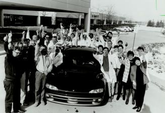Thumbs' up favorite: Showing off one sedan - the Chrysler intrepid - in its Car of the Year lineup yesterday are representatives from every area of Chrysler Canada's Brampton plant who make it