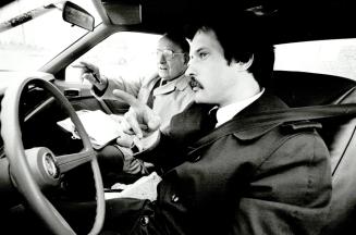 What now? Reporter Rick Brennan, at the wheel and ready to try a driving test at the John Rhodes Centre, gets instructions from examiner Jack Oates. B(...)