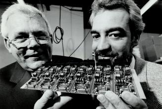 Wiper controls: Patrick Vierira, right, of Bridge Technologies, displays circuit boards for George Rawlings, of SWF Auto Electric, which makes wipers for Saturn cars