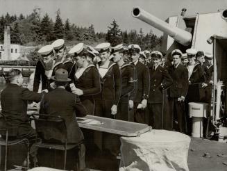 It's pay parade as these sailors of the Canadian cruiser, Uganda, line up to receive their pay before going on leave