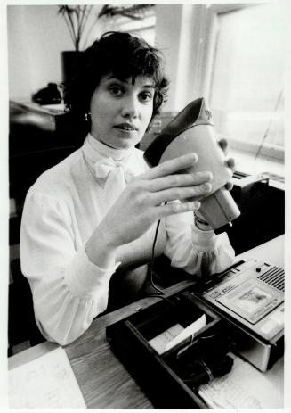 Mask: Colleen Cleveland shows her soundproof stenomask, which is connected to a tape recorder, a device used by many court reporters