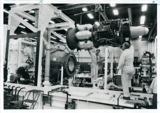 Canadian Powerplant for Arabian Oil, Big 6,000-horsepower industrial gas turbine is lowered gently by Harry Rudge (at controls) and Joe Chapman into o(...)