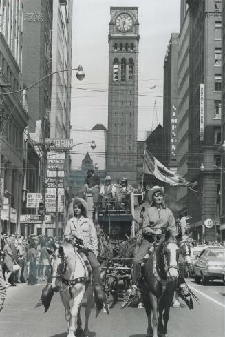 Circus parades through town, A pair of pretty outriders leads an 1897 calliope down Bay St