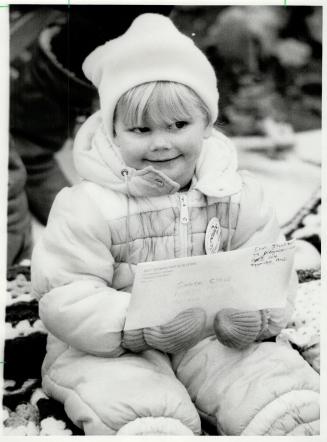 Erin Thatcher's letter, above, was for Santa but other paraders, like the clown at right still manage to catch the 3-year-old's eye