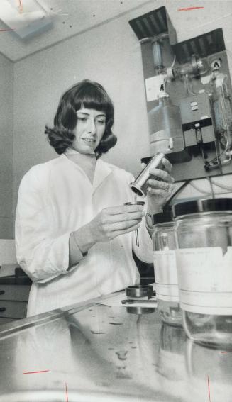 Technologist Jane Dillon prepares water from the Canadian Johns-Manville plant for testing at the Ontario Research Foundation