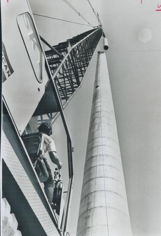Steel liners as much as 60 feet long and weighing up to five tons are slipped into the 320-foot-high anti-pollution smokestack at the St. Lawrence Sta(...)