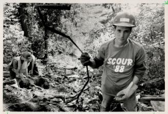 River clean-up yields 39 cars, Don Stacey holds twisted metal he found down the side of a steep ravine in the Humber River Valley west of Kleinberg