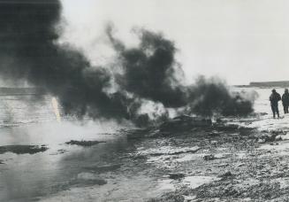 Dirty black smoke rises from the polluted shore of Chedabucto Bay in Nova Scotia in an experiment to get rid of the mass of oil from the wrecked tanke(...)