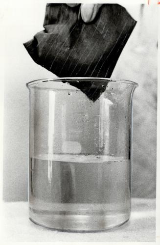 Pad with Imbiber Beads soaks up pollutant in beaker of water