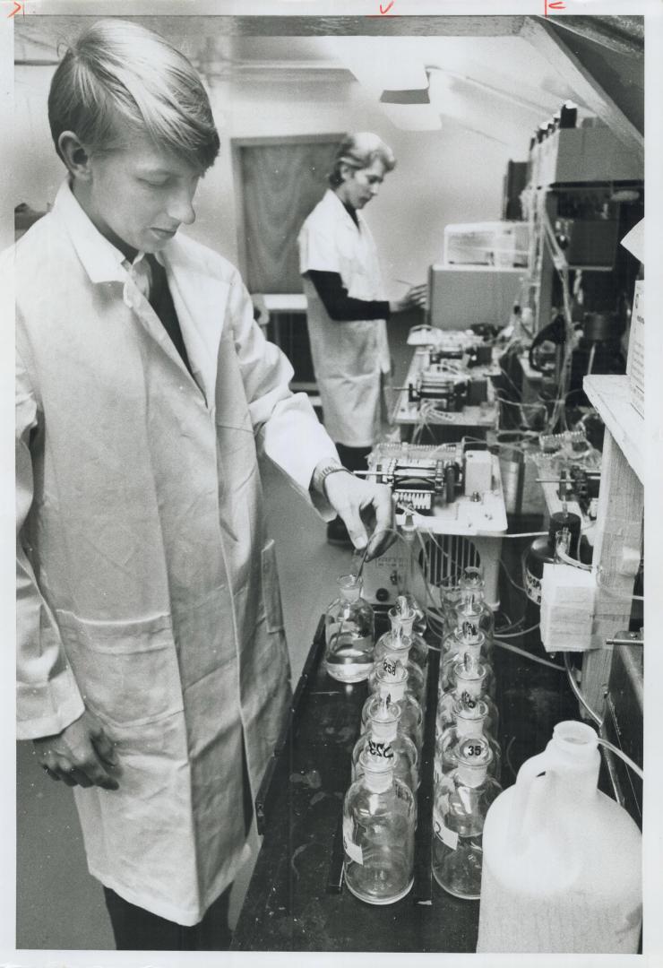 Lab technicians Keith Austen (foreground) and Harry Alkema test Lake Ontario water samples for nutrients aboard the motor vessel Martin Karlsen, a floating pollution research laboratory