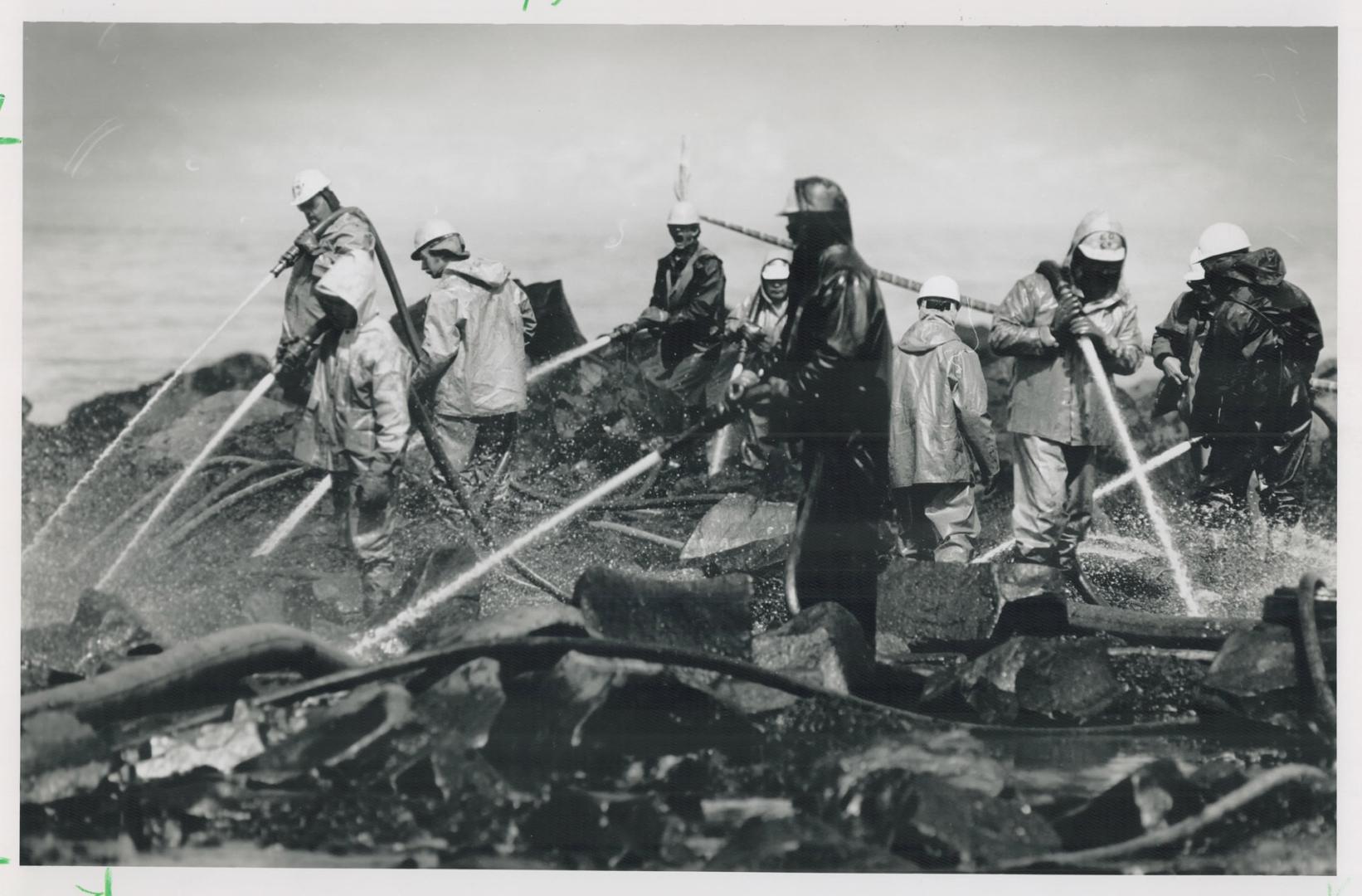 Hosing down: Workers with high-pressure hoses use warmed water to clean a Prince William Sound beach