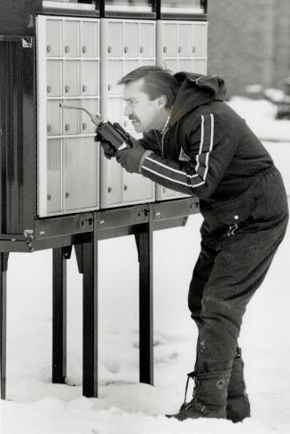 Through sleet and snow . . . Tom Jupp resorts to a blow torch yesterday to get his mail from a Mississauga supermailbox when it became frozen shut. It worked