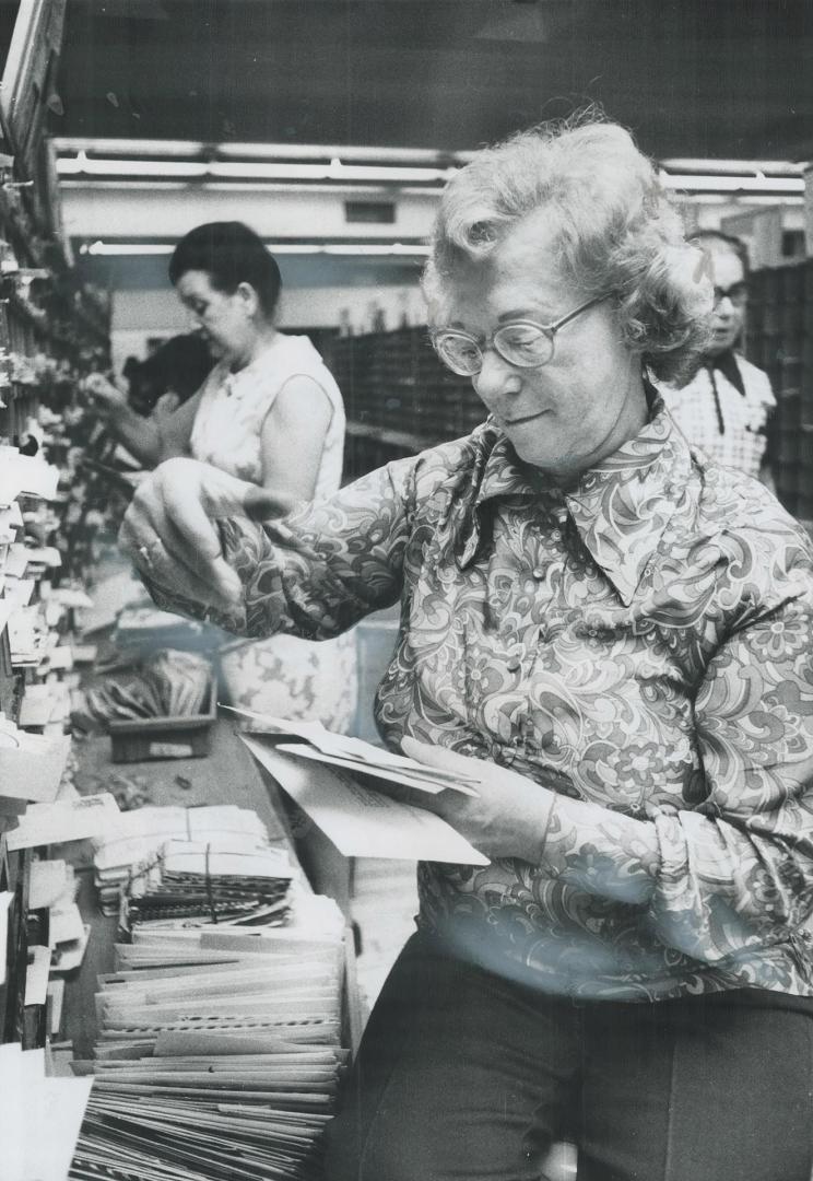 Letters addressed to a name and a city only must be hand sorted, postal worker points out below