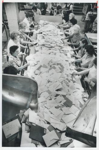 Letters and Christmas cards are sorted along the sides of a conveyor belt