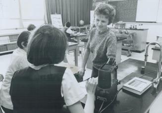 Mrs. George Crawford, a teacher at Grandview school, gives individual instruction to one of the girls in the science class. There's another school in (...)