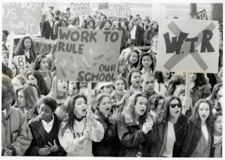 Class action: Catholic high school students carry signs as they gather at Queen's Park today to urge an end to a work-to-rule campaign by teachers volved in a contract dispute with their board