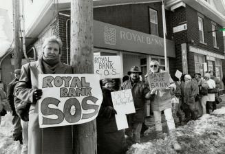Signs say it all, Elizabeth Stalte (left) an about 40 other customers of the Royal Bank branch in Caledon Village let their signs tell how they feel a(...)