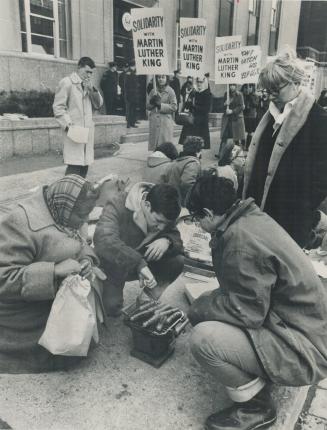 Sustenance against the cold weather during vigil outside the consulate is prepared on tiny stove by Bob Lackie and Kenneth Dent while Margaret Smith w(...)