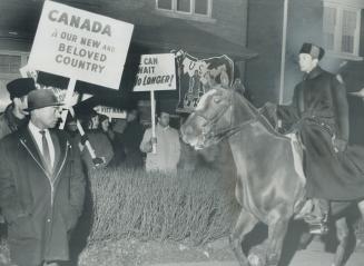 Mounted Policemen charge into mob of demonstrators last night outside the Yugoslavian consulate on Spadina Rd