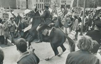 Mounted Police officer is surrounded by demonstrators protesting the Viet Nam war, outside the U
