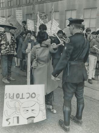 A Peace March Erupts in anger, An angrily emphatic woman demonstrator, backed by crowd of anti-Viet Nam war marchers, argues with a Toronto policeman (...)