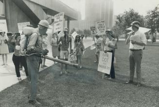 Anti-pollution demonstrators take a breather on Queen's Park march today to bug John Levick as he sprays City Hall trees with arsenate of lead. [Incomplete]