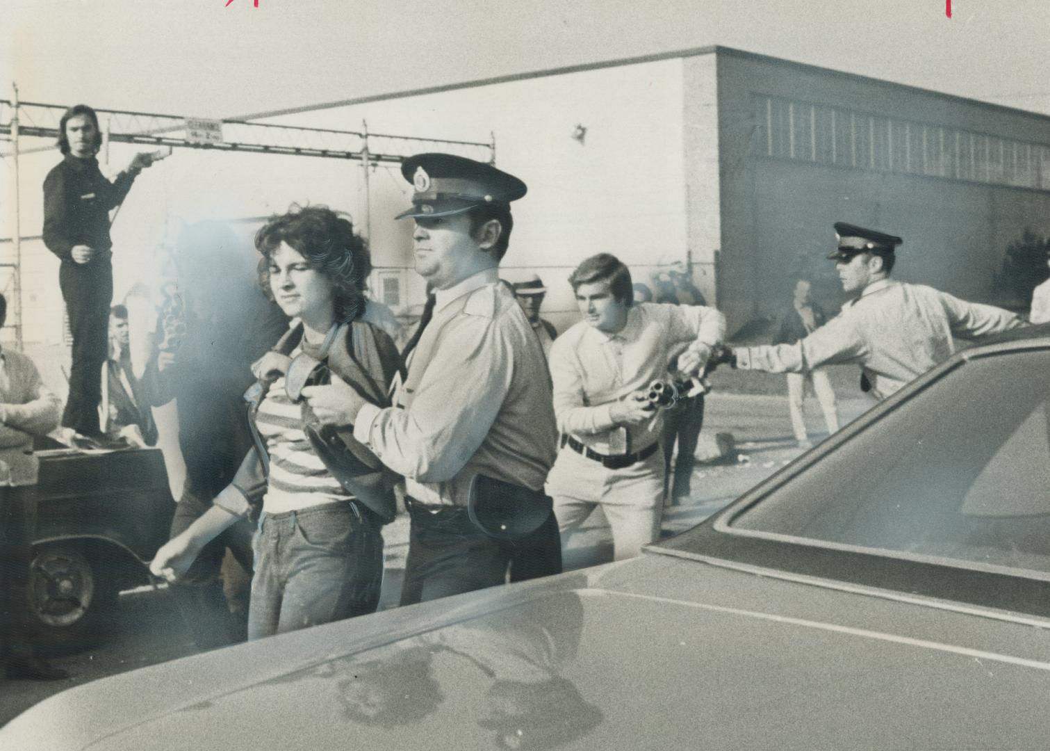 In picket line skirmish outside an auto parts plant in Etobicoke yesterday, a police constable leads away Lorrie Cecelia Atlee, 18, of Hamilton, while(...)
