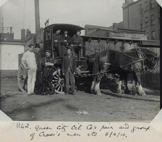 A group of men posed with a machine and a pair of work horses