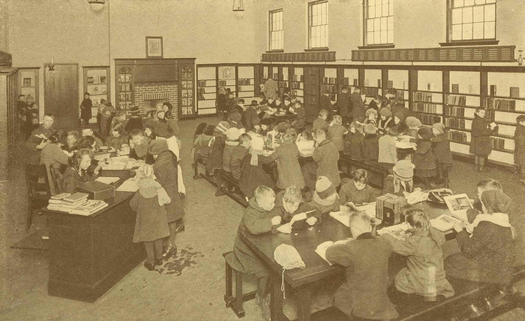 Readers at tables inside large library room